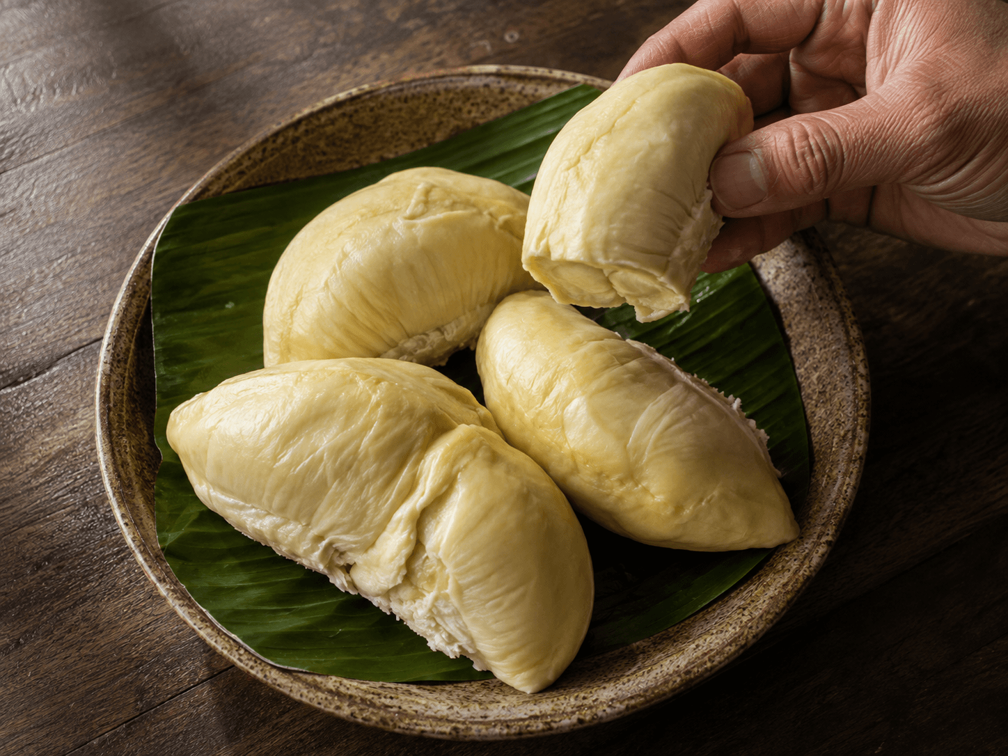 Ulas daging durian Montong kuning pucat ditata di piring beralas daun pisang